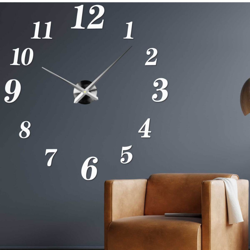 Adhesive wall clock made of black plexiglass on a white wall