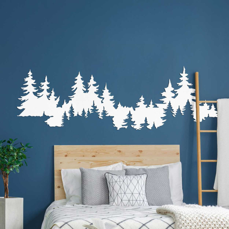 Close-up view of a forest silhouette made of wood mounted on a white wall.