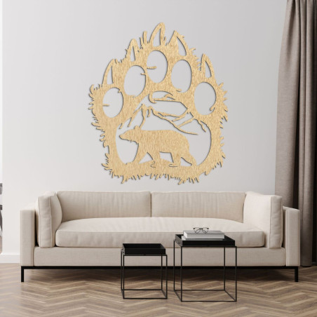 Carved shape of a large bear paw with four claws and a detail of a landscape with mountains and a bear in the middle.