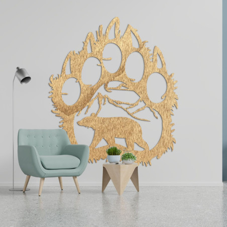 A wooden image of a bear footprint, inside of which is carved the silhouette of a bear walking under the mountains.