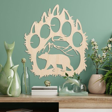 A contrasting silhouette of a bear track, inside which a mountain range and the figure of a bear walking forward can be seen.