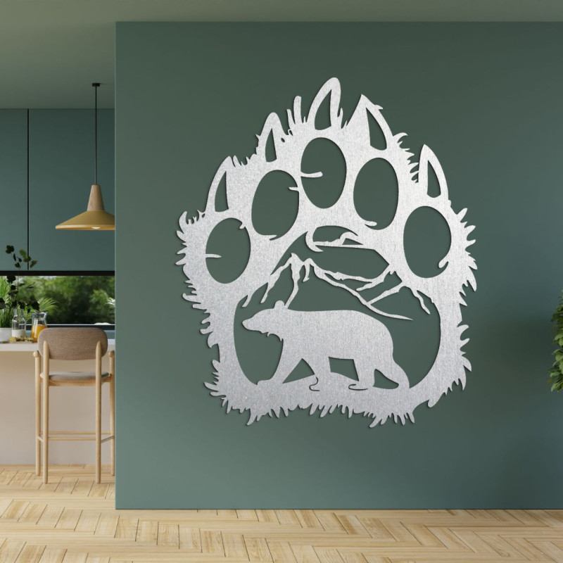 A wooden image of a bear footprint, inside of which is carved the silhouette of a bear walking under the mountains.