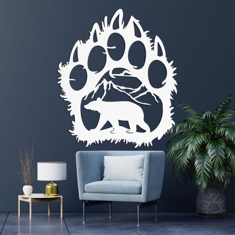 A wooden image of a bear footprint, inside of which is carved the silhouette of a bear walking under the mountains.