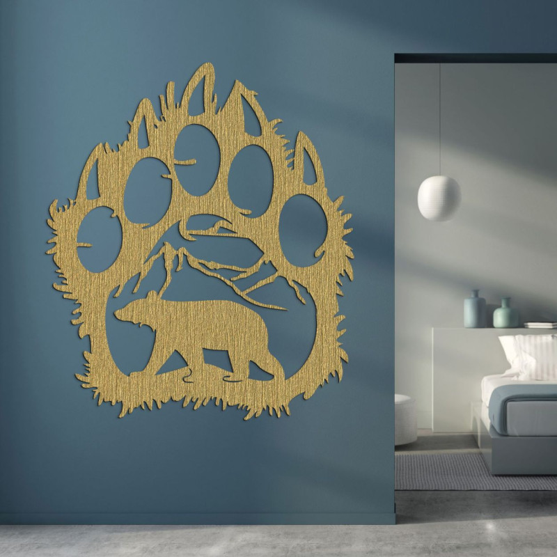 A wooden image of a bear footprint, inside of which is carved the silhouette of a bear walking under the mountains.