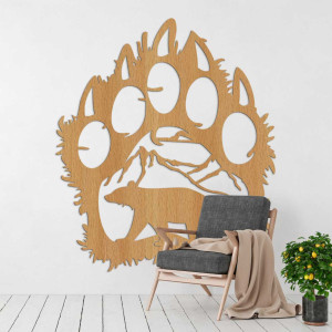 Wooden wall decoration in the shape of a bear footprint with a carved bear and mountains.