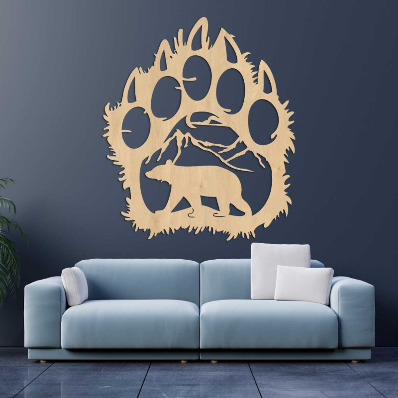 A close-up view of a natural motif of a bear and mountains inside a large wooden paw.