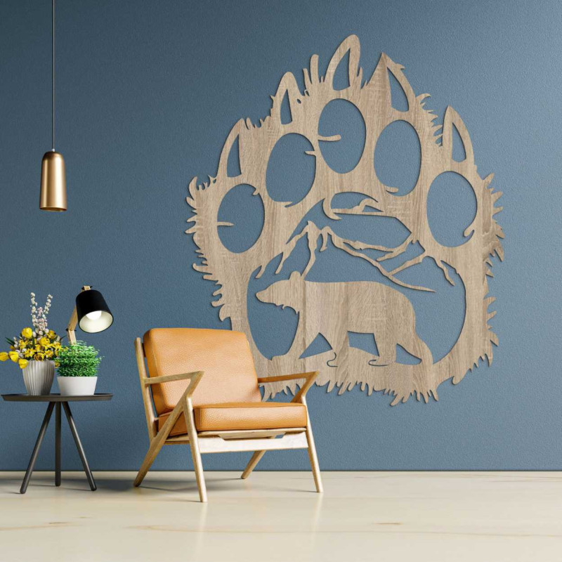 A close-up view of a natural motif of a bear and mountains inside a large wooden paw.