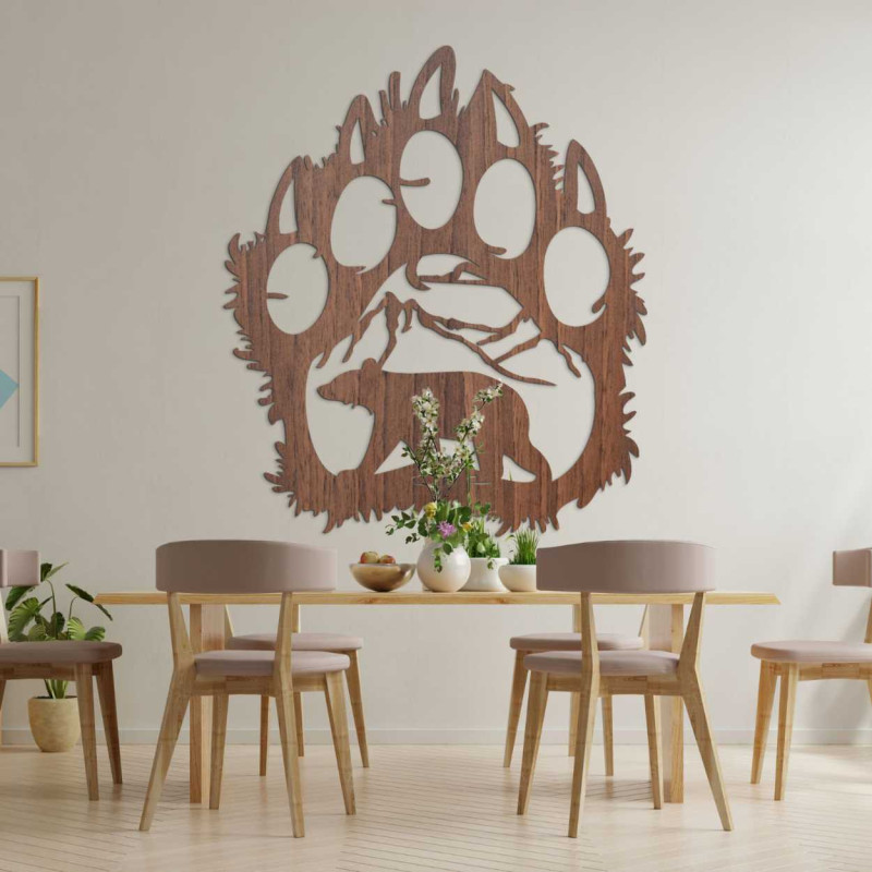 A close-up view of a natural motif of a bear and mountains inside a large wooden paw.