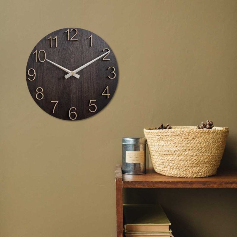 Round wooden clock with a subtle natural motif and legible numbers.