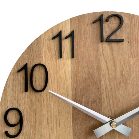 Round clock made of natural wood with contrasting metal hands.