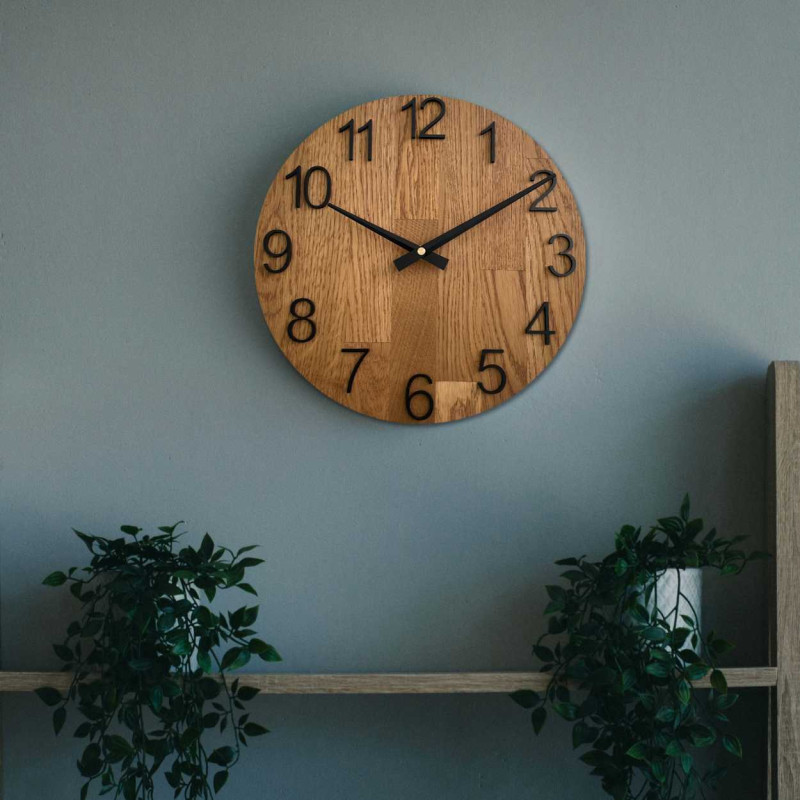 Carved wooden clock with a simple dial and minimalist design.