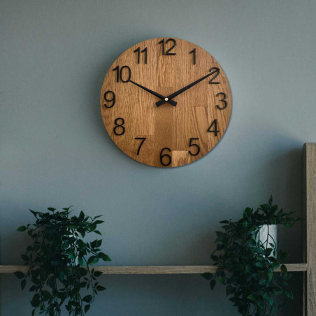 Carved wooden clock with a simple dial and minimalist design.