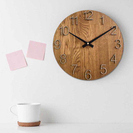 Wooden wall clock with a circular shape and a subtle natural motif.