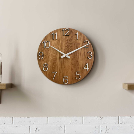 Wooden wall clock with a circular shape and a subtle natural motif.