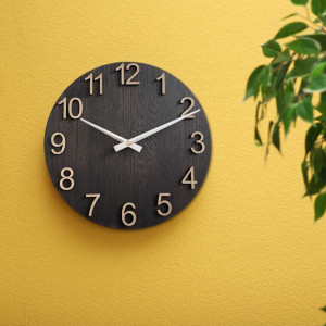 Modern wooden clock with a round shape and a discreet dial