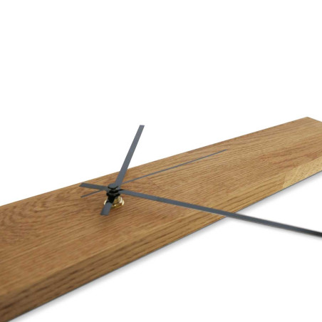 Minimalist wooden clock in the shape of a narrow panel with silver and black hands.