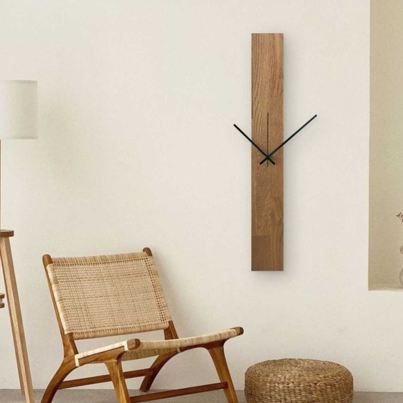 Vertical wooden clock with combined black and silver hands without numbers.