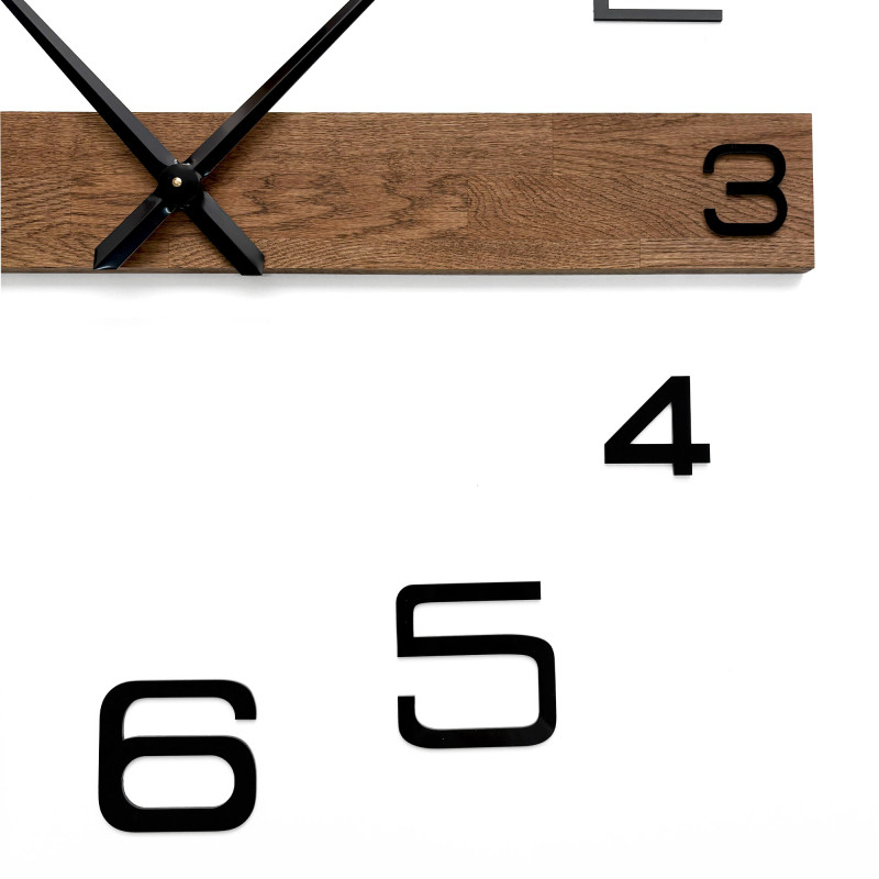 Modern and inexpensive wooden clock with dark hands and black separate digits.