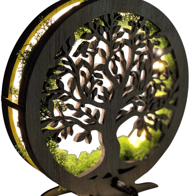 A close-up view of a backlit wooden Tree of Life surrounded by moss.