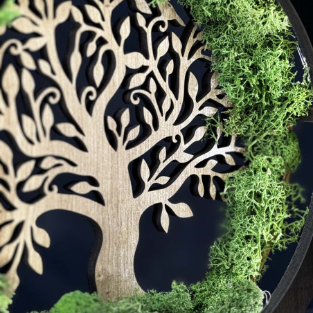 A close-up view of a backlit wooden Tree of Life surrounded by moss.