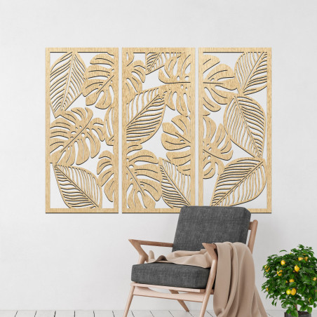 Modern wall decoration: three panels with cutouts of monstera leaves.