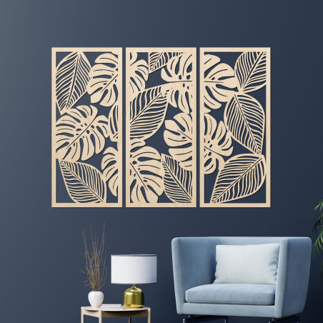 Modern wall decoration: three panels with cutouts of monstera leaves.