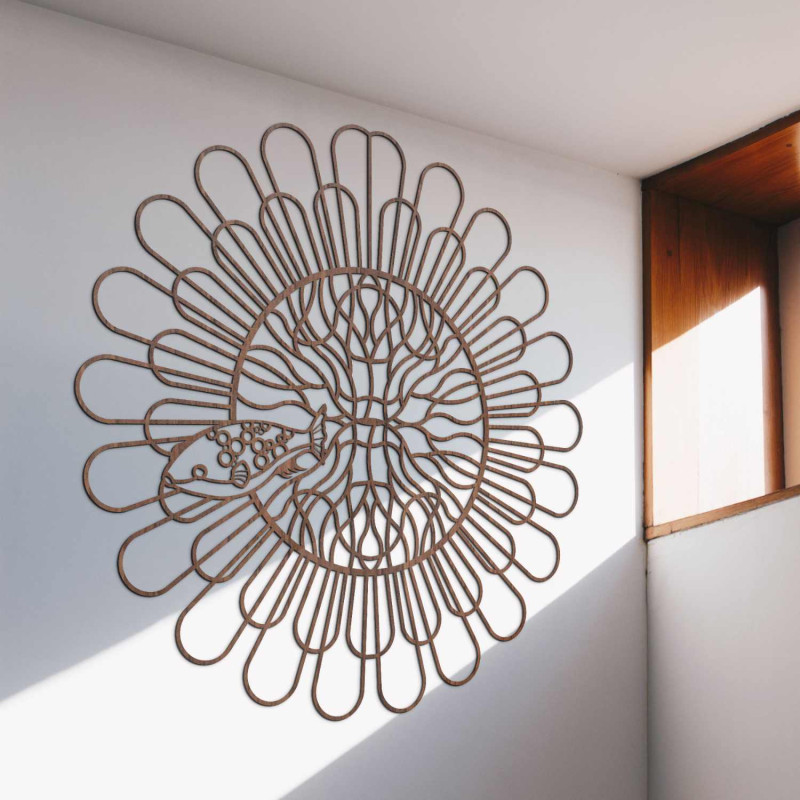 Black wooden mandala with fish on a white wall in a modern apartment