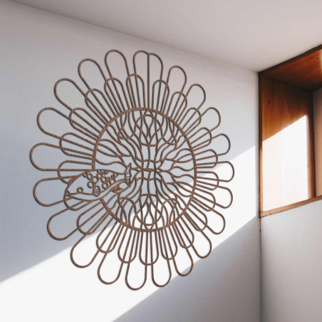 Black wooden mandala with fish on a white wall in a modern apartment